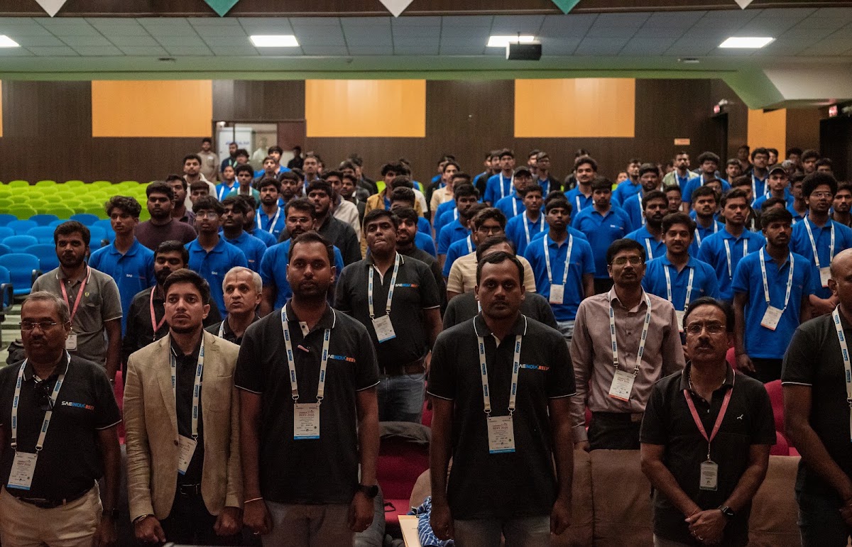 Full auditorium of student participants standing during a REEV technical session at GITAM University