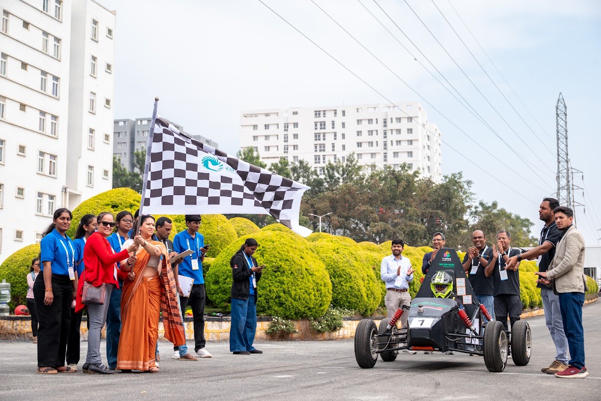 Ceremonial flag-off of a REEV vehicle on the endurance run, with a guest of honour waving the chequered flag